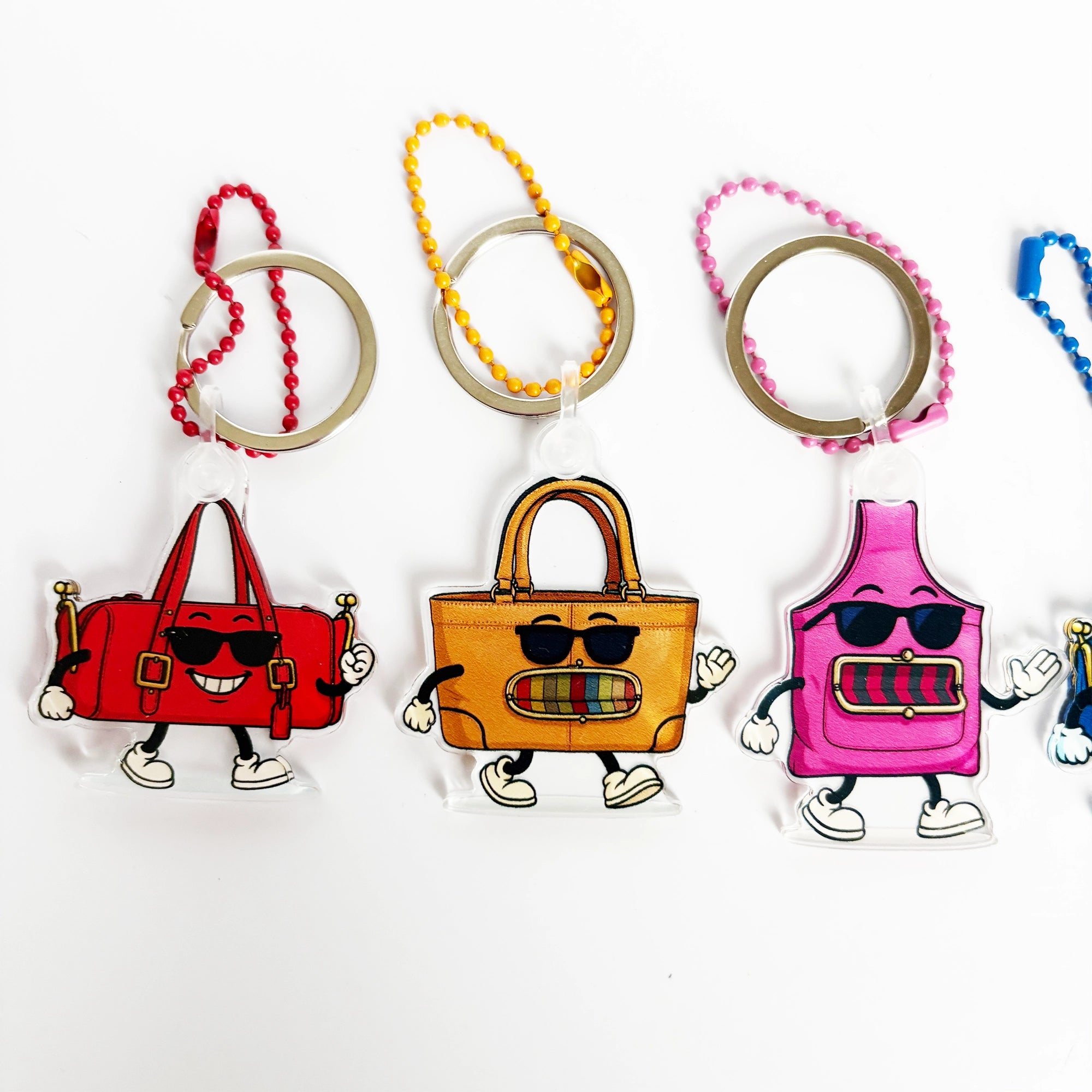 Colorful cartoon-style handbag keychains on a white background