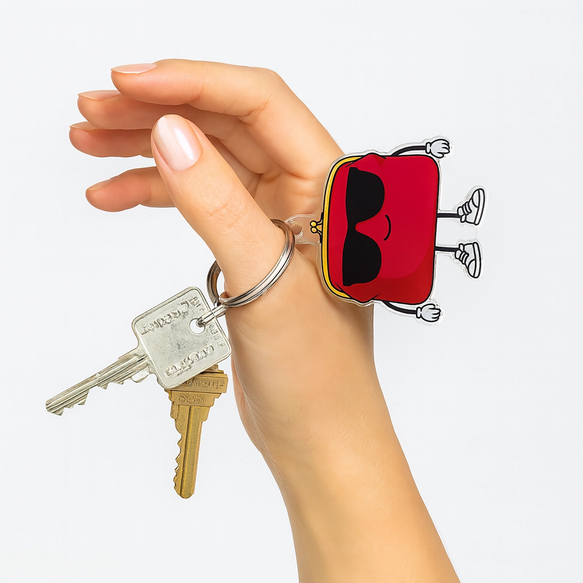 Hand holding a key with Charmlingz Flopsy keychain bag charm shows scale.