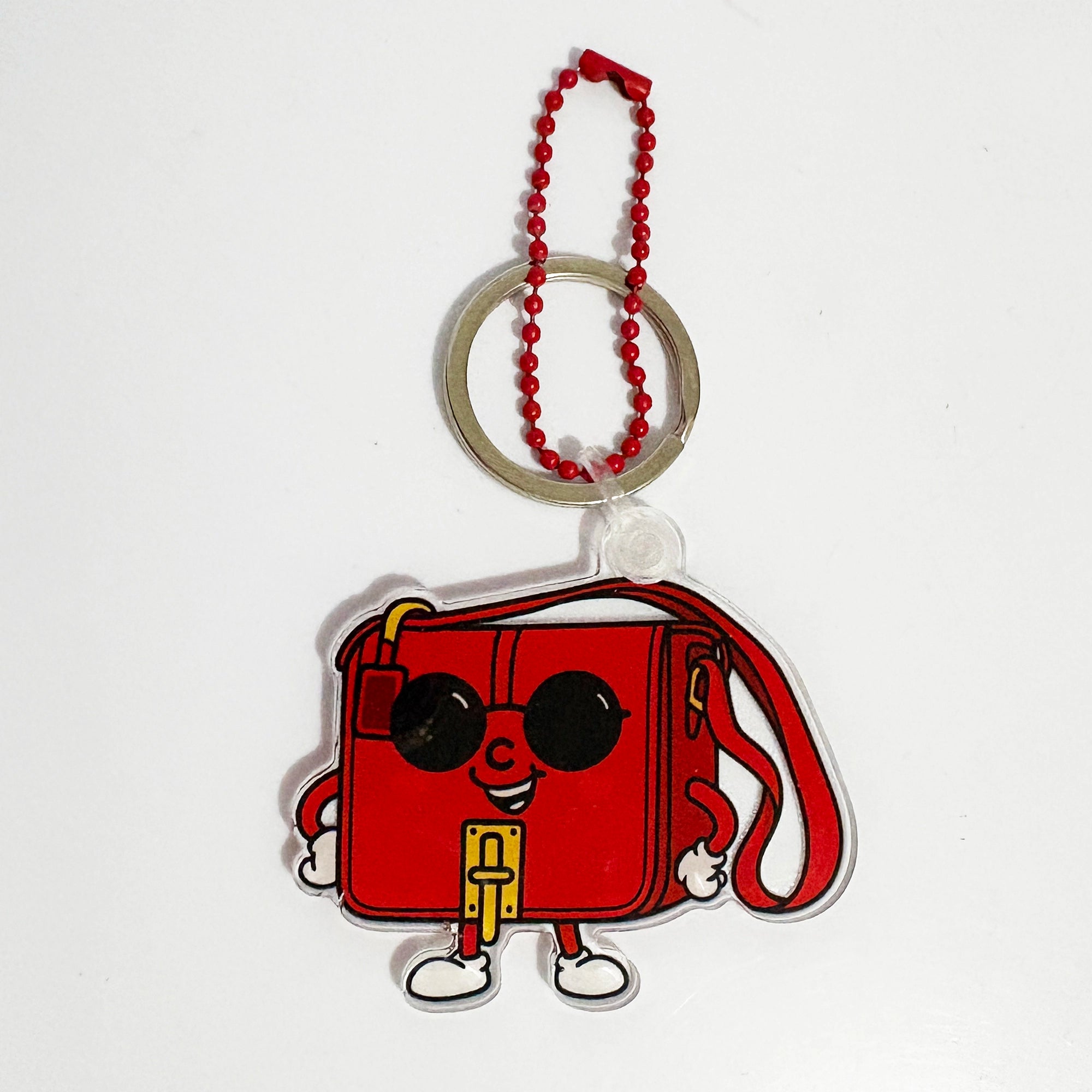 Red cartoon-style bag keychain bag charm with a beaded chain on a white background