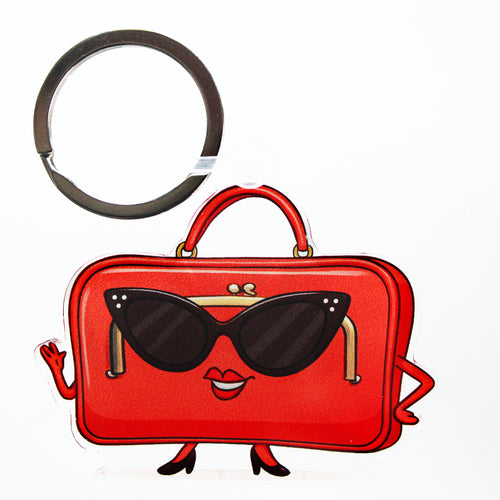 Red handbag keychain with sunglasses and a smiling mouth on a white background