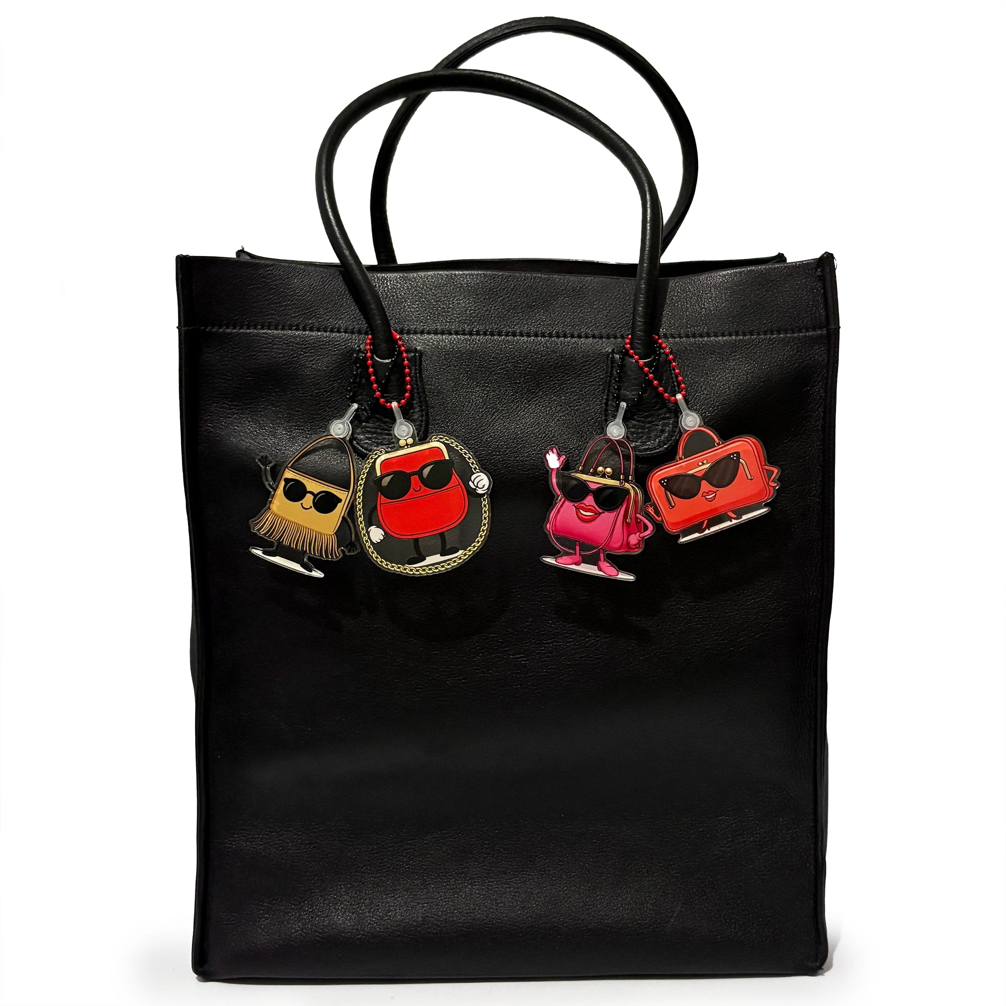 Black tote bag with colorful Charmingz bag charms keychains on a white background