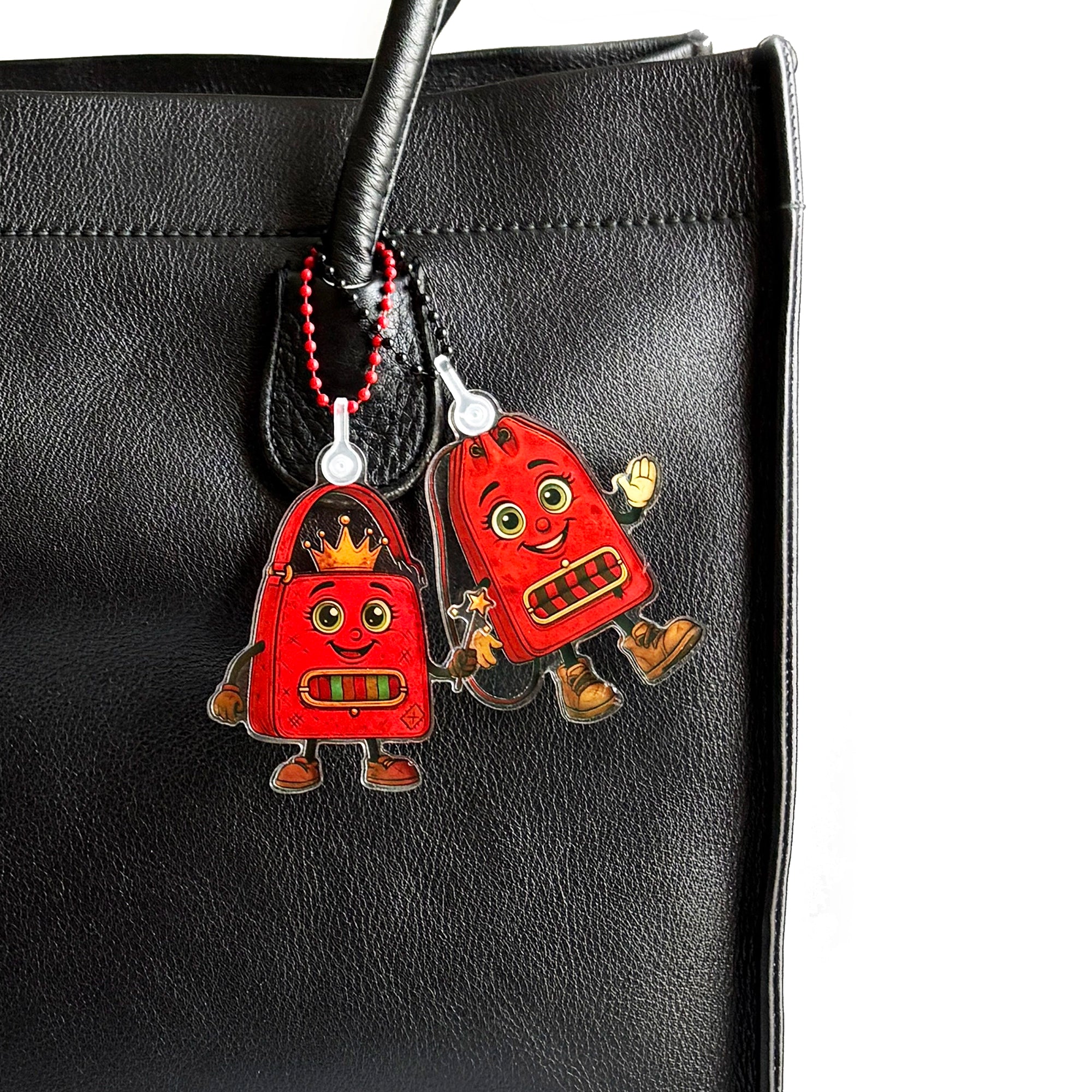 ReLuvable Fee Dee and Duffy  handbag charms attached to a vintage black leather bag.