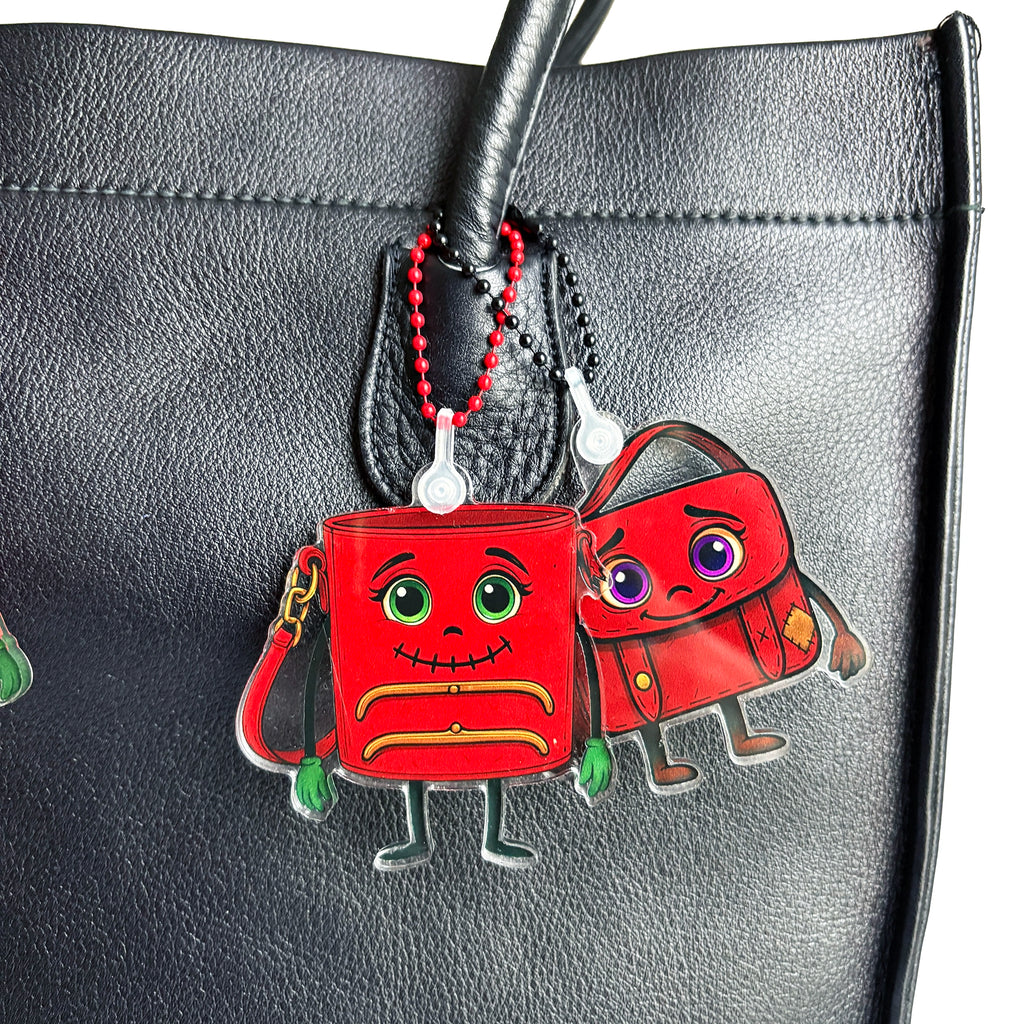 Two ReLuvable bag charms TriFramea and Musey on a black vintage  leather bag.